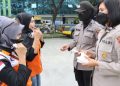 Polwan bagi-bagi masker saat demo buruh di Kemnaker