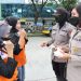Polwan bagi-bagi masker saat demo buruh di Kemnaker