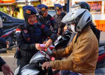 aksi pembagian bendera merah putih oleh Polwan Korbrimob menjelang HUT ke-80 Kemerdekaan RI