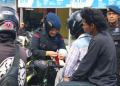 pembagian bendera merah putih oleh Satbrimob Polda Sulawesi Tengah untuk HUT ke-80 RI